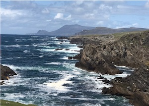 view across rough sea to cliffs in Ireland